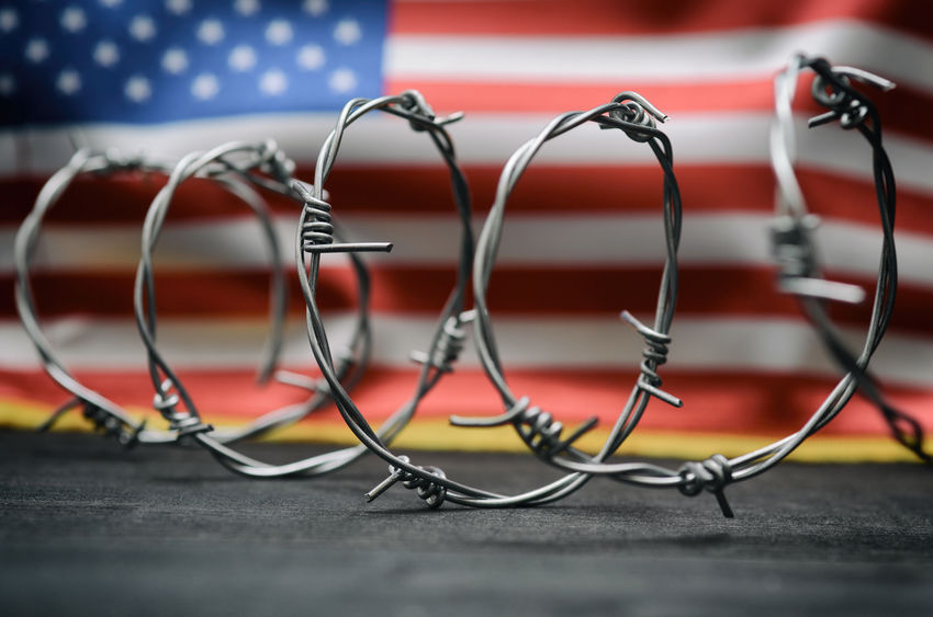 Barbed wire and United States of America flag , immigration stock photo. Barbed wire and United States of America flag , immigration stock photo.