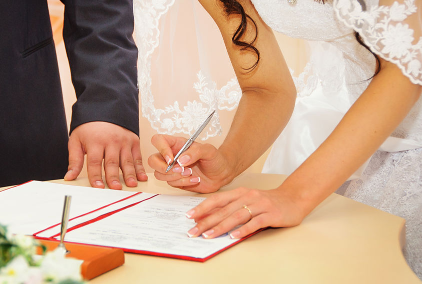 Bride signing marriage license or wedding contract