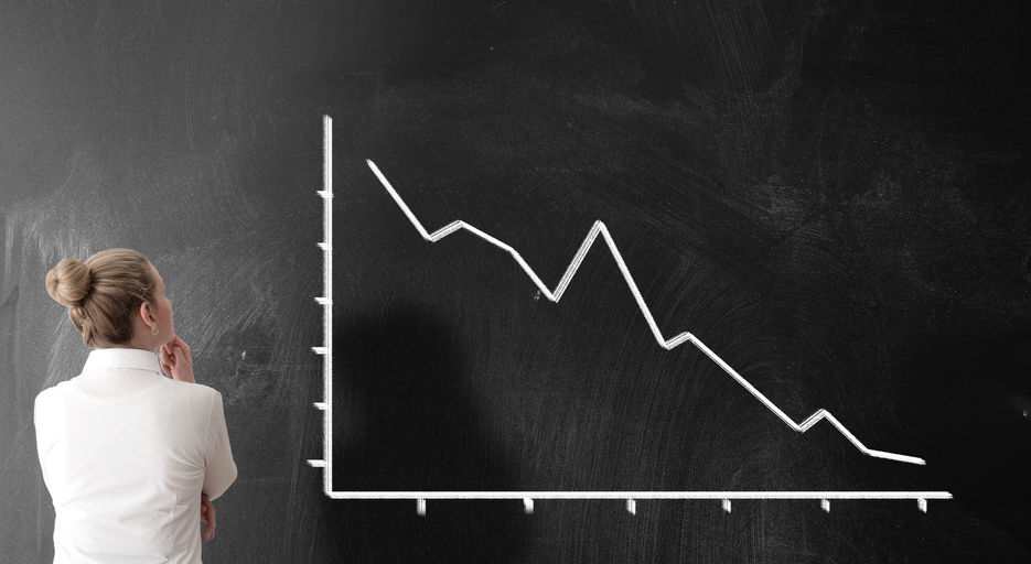 rear view of businesswoman looking at negative chart with dropping prices
