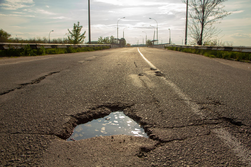 there are many potholes on the roadway close up