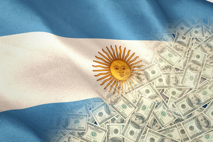 Pile of dollars against digitally generated argentinian national flag